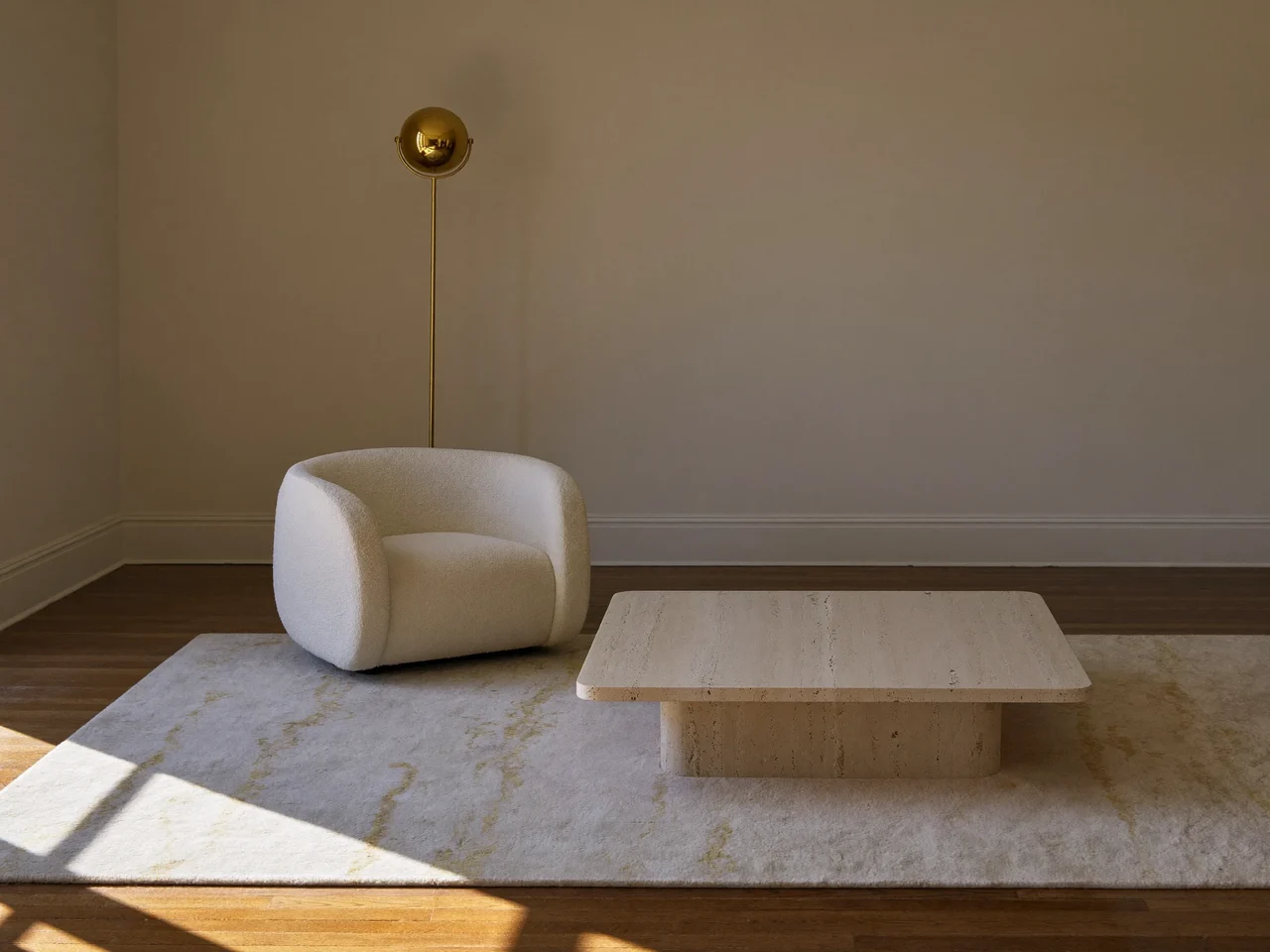 Concept de salon avec fauteuil bouclé, tapis en laine et lampadaire en laiton